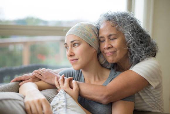 Two people hugging on sofa whilst looking out window